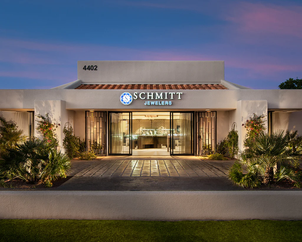 Schmitt Jewelers storefront at twilight, warm interior light spilling through the entrance